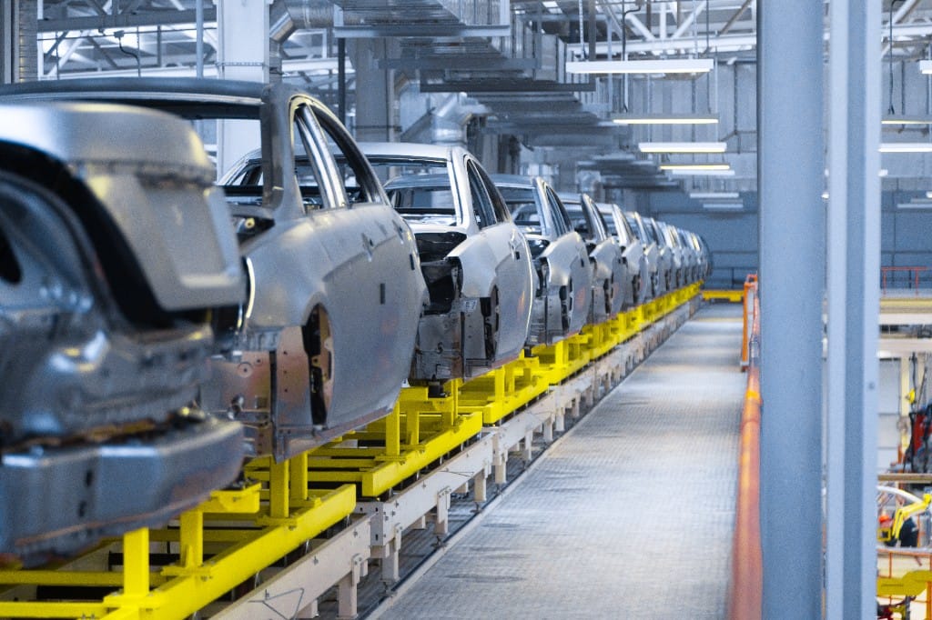 Línea de montaje automotriz con carrocerías en transporte industrial