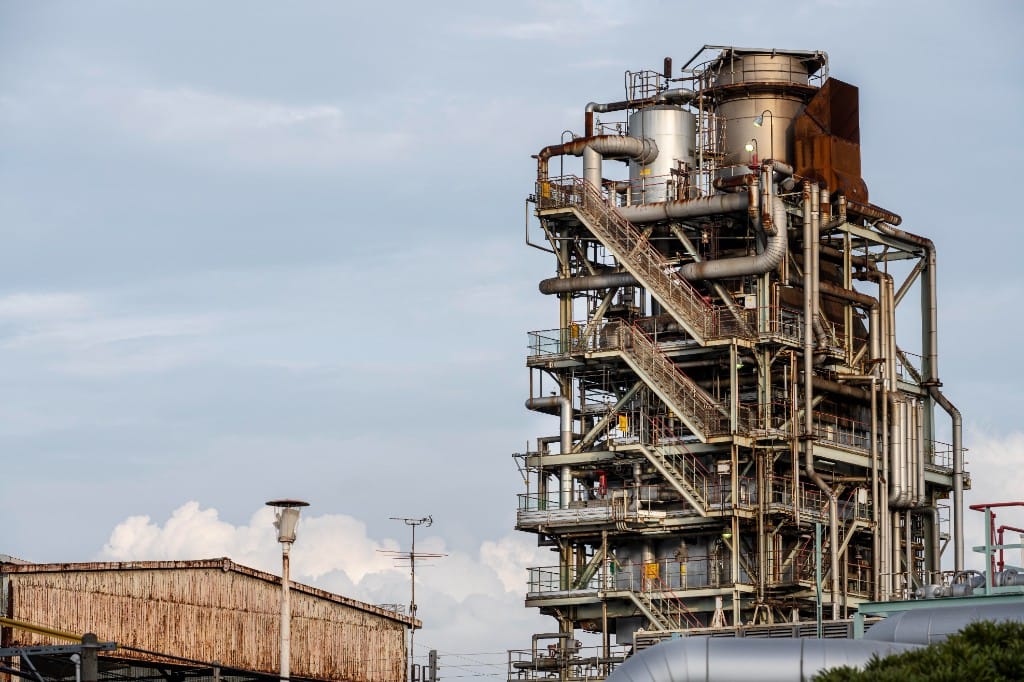 Torre de proceso en planta química con tuberías y estructuras industriales